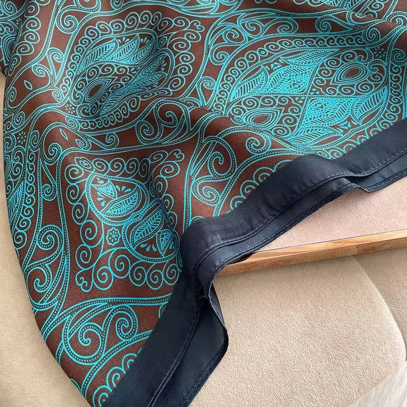 Teal and brown paisley patterned fabric draped over a chair.