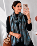 Blue patterned scarfwrapped around the models neck elegantly 