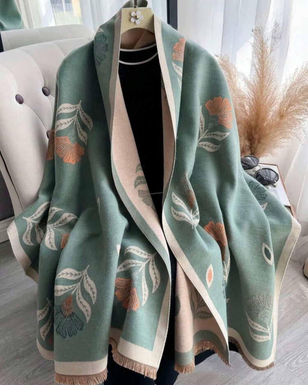 Green floral patterned scarf draped over a chair with a neutral background