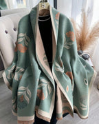 Green floral patterned scarf draped over a chair with a neutral background