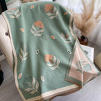 Floral patterned blanket on a surface with decorative elements in the background