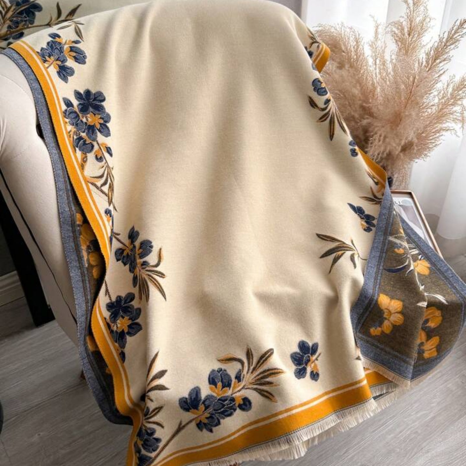 Floral patterned blanket draped over a chair with a neutral background