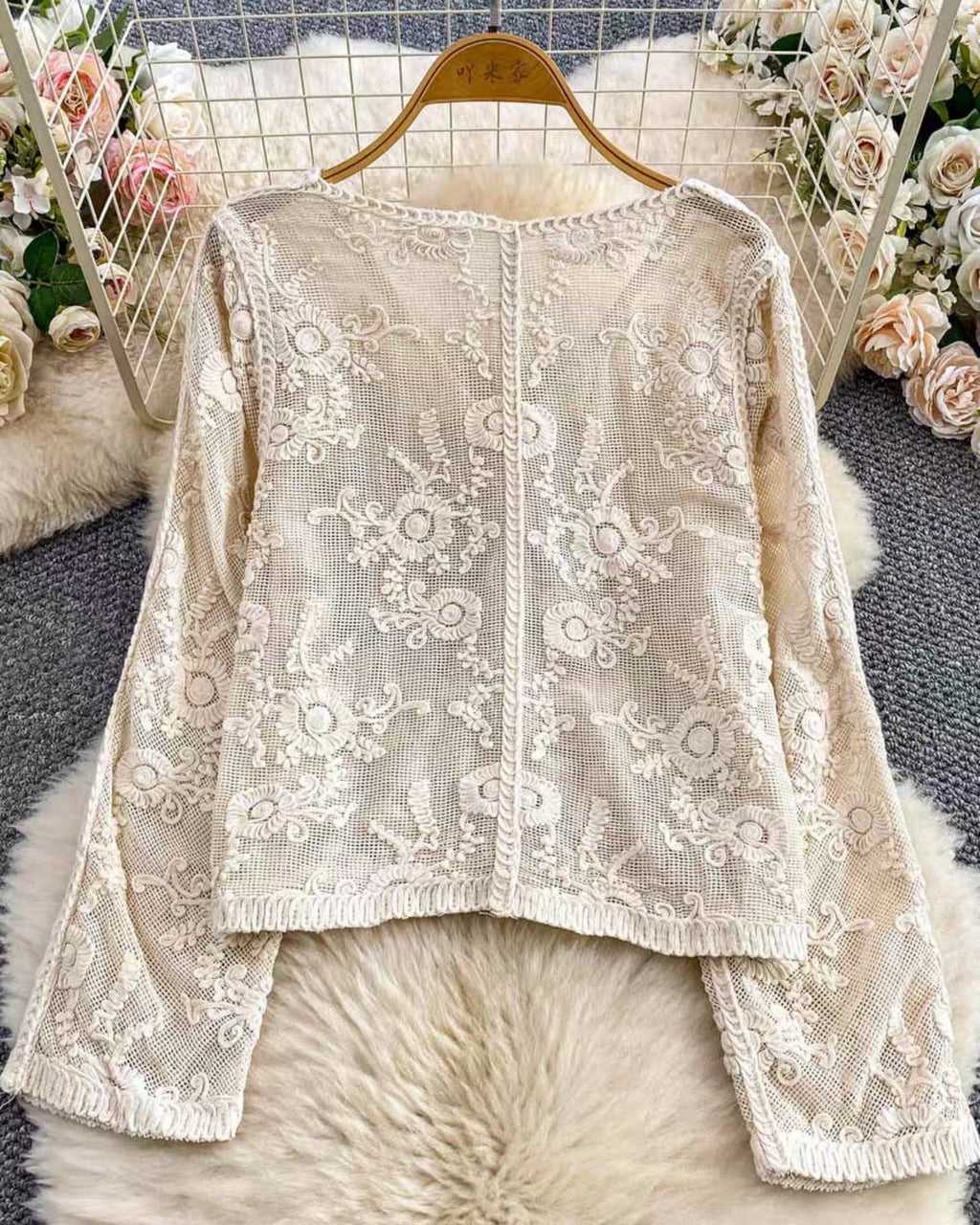 Lace top on a hanger with floral decorations in the background