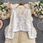 White lace top on a hanger with floral decorations in the background