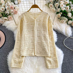 Beige crochet cardigan on a hanger with floral decorations in the background