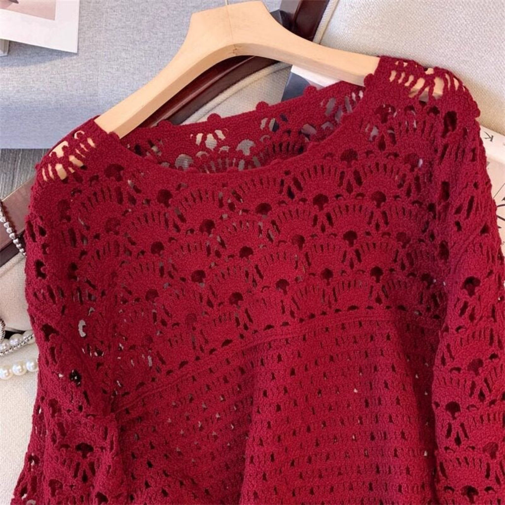 Red crochet top on a hanger against a neutral background