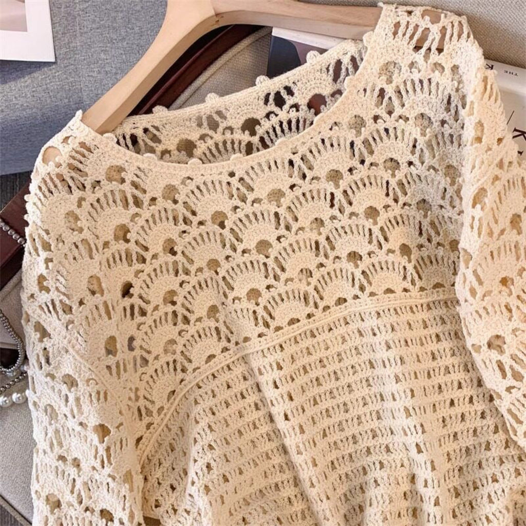 Beige crochet lace garment on a hanger against a neutral background
