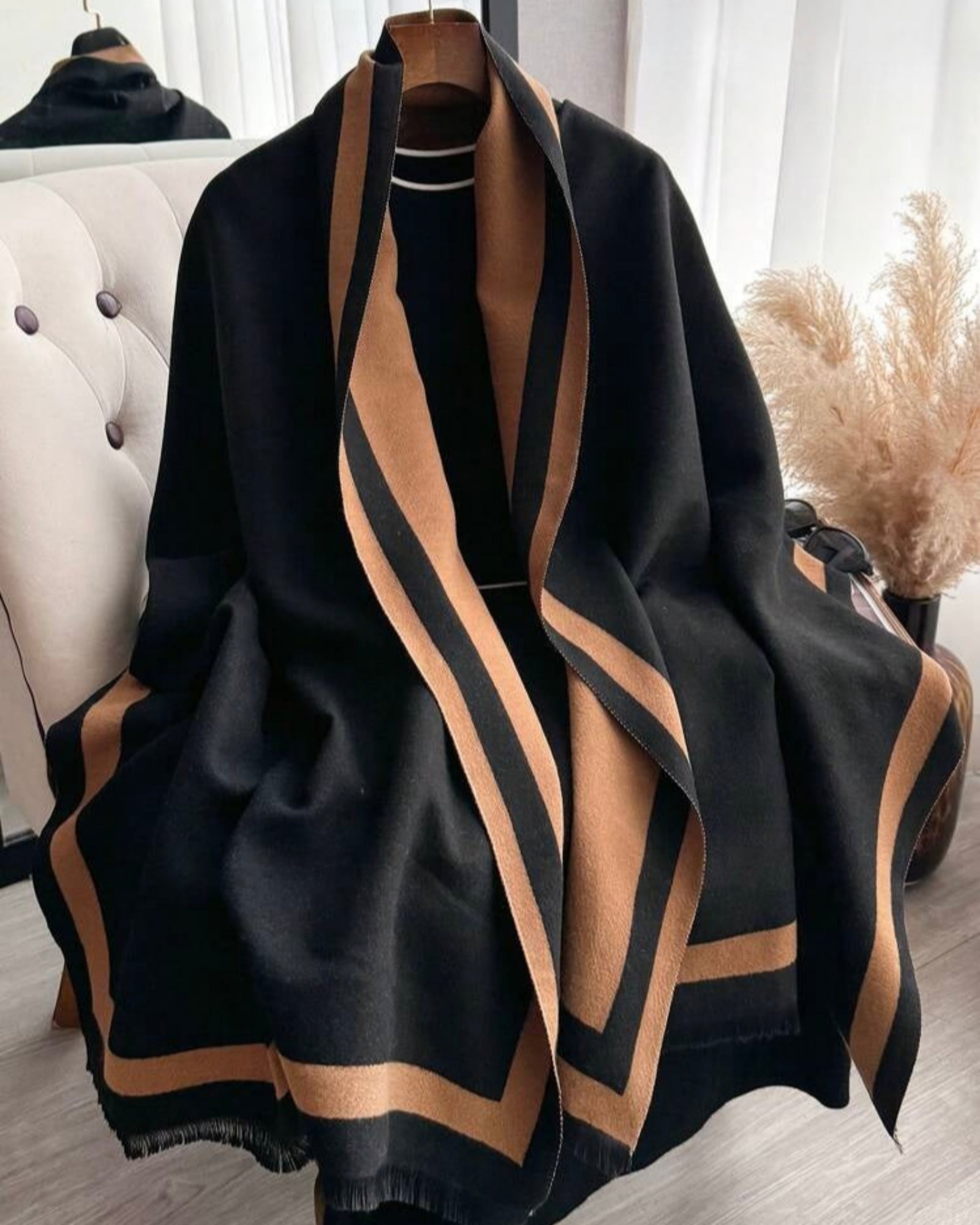 Black and brown striped scarf on a mannequin against a neutral background