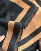 Close-up of a black and brown striped fabric with frayed edges.