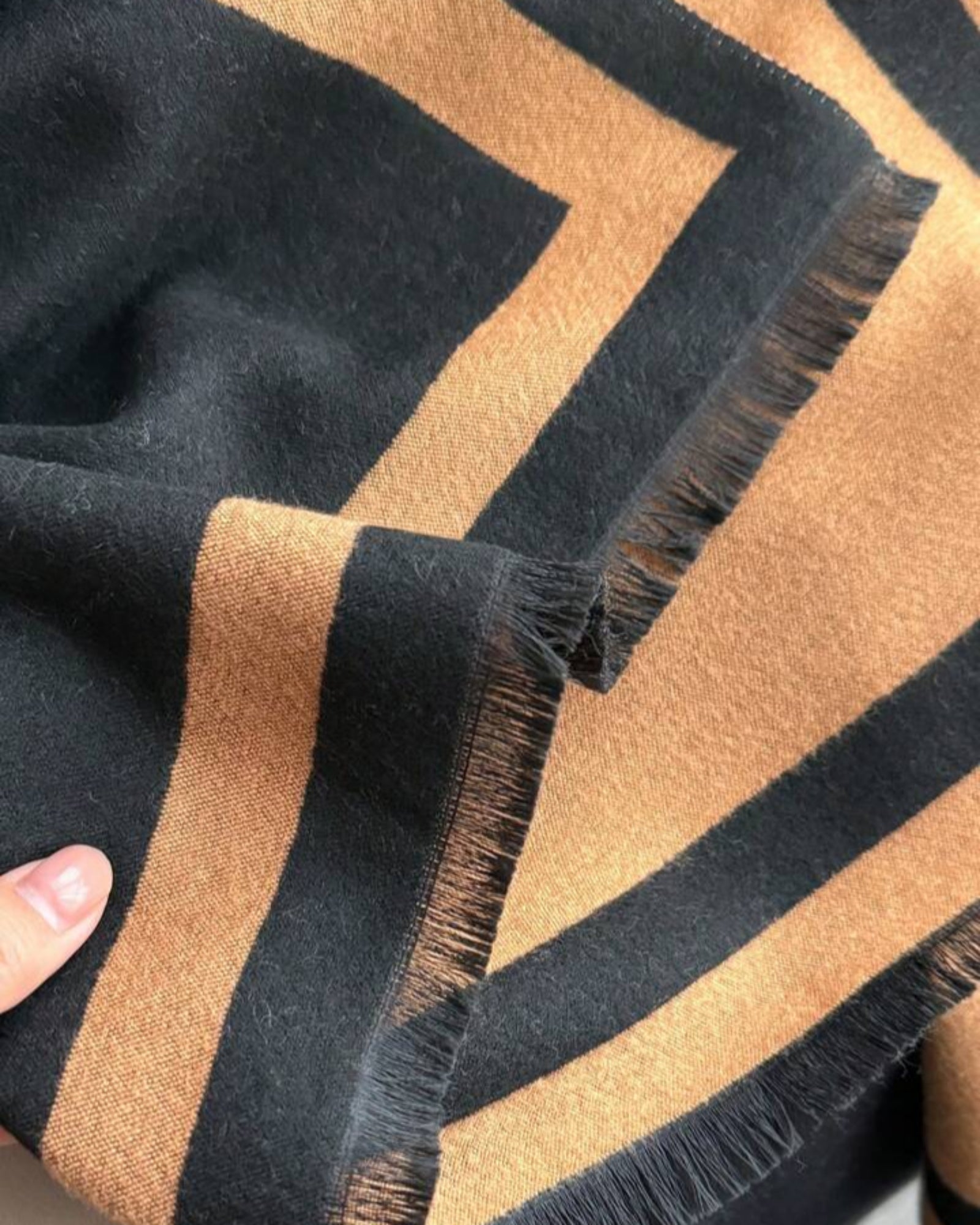 Close-up of a black and brown striped fabric with frayed edges.