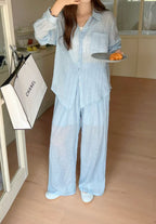 The Soleil Crinkle Cotton Co-ord in Mist — sky blue button-down shirt and wide-leg pants, home interior lifestyle shot