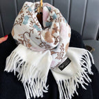 Floral patterned scarf with white fringe held by a person against a gray background