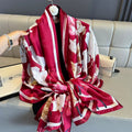 Red floral patterned scarf draped over a light gray sofa.