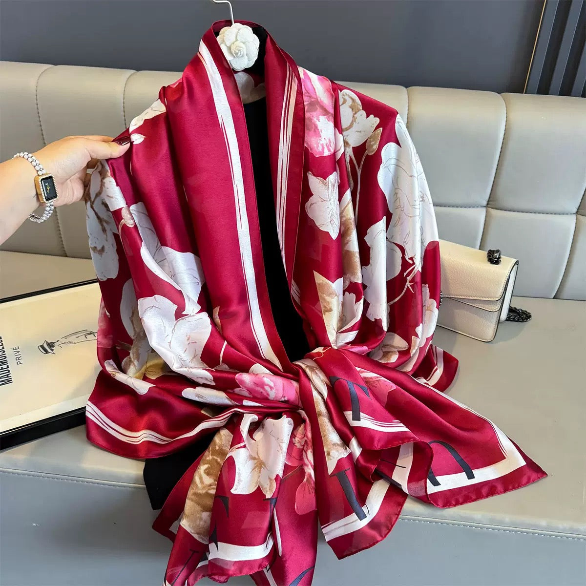 Red floral patterned scarf draped over a light gray sofa.