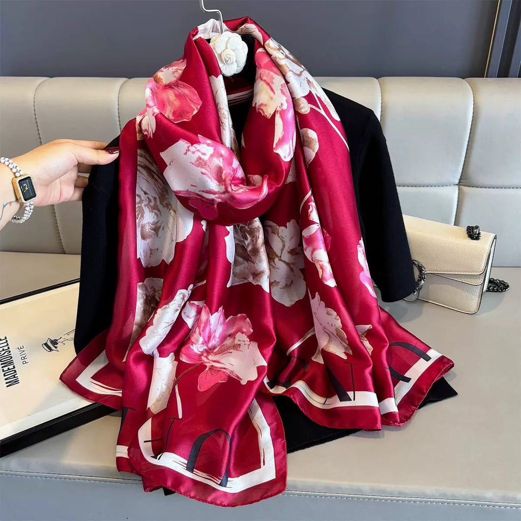 Red floral scarf draped over a black garment on a light gray sofa.
