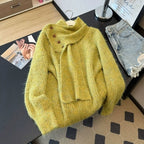 Close-up of yellow-green textured knit sweater showing the coordinating scarf and button detail