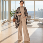 Woman wearing a beige knit co-ord set with monochrome houndstooth wrap