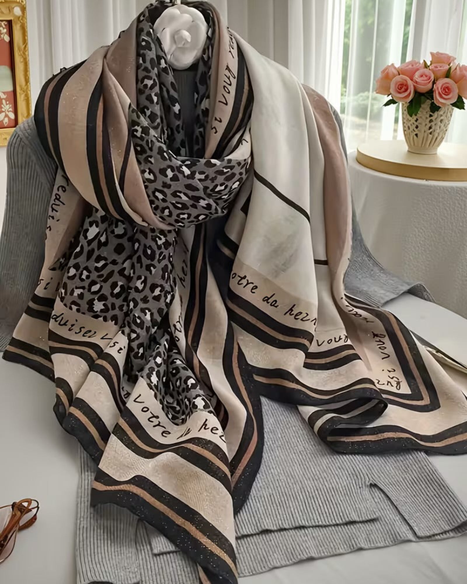 Leopard print viscose cotton stole draped showing French text and striped border detail