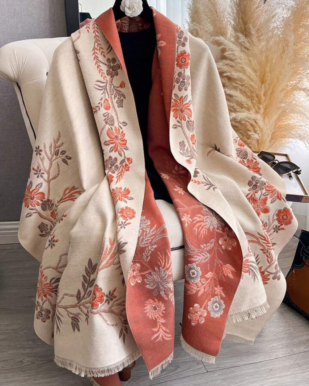 The Blush Botanica Reversible Wrap showing primary blush pink side with soft botanical floral motifs on faux cashmere fabric
