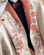 Close-up of The Blush Botanica Reversible Wrap showing soft faux cashmere fabric texture with delicate blush botanical floral motif detail
