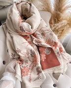 The Blush Botanica Reversible Wrap draped and styled showing botanical print detail on the reversible contrasting colour side
