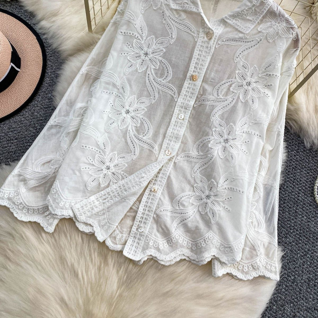 Close-up of Camellia Bloom Embroidered Linen Shirt floral embroidery, silver embellishment, and scalloped hem