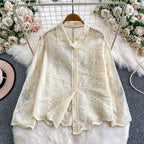 Camellia Bloom Embroidered Linen Shirt in ivory displayed on hanger showing full floral embroidery