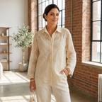 Woman wearing Camellia Bloom Embroidered Linen Shirt in ivory with floral embroidery detail