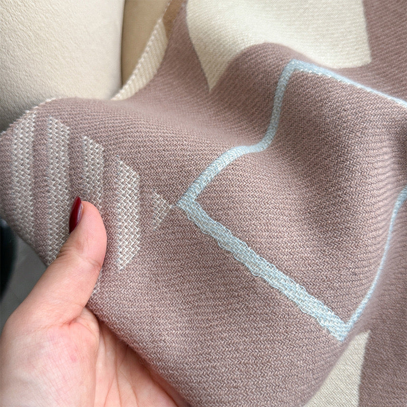 Close-up of Chic Reversible Winter Poncho Shawl showing soft imitation cashmere fabric texture with geometric print in rose and teal tones
