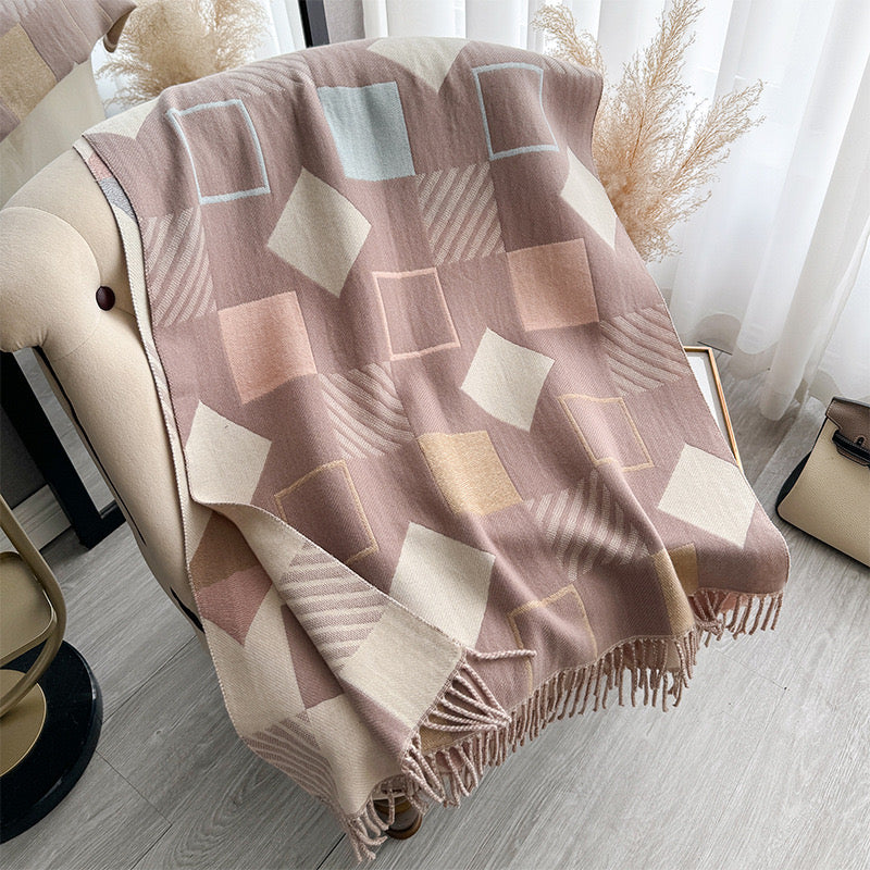 Chic Reversible Winter Poncho Shawl laid flat showing full geometric square print in dusty rose beige and cream tones with fringe edges
