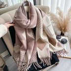 Chic Reversible Winter Poncho Shawl gathered in hand showing blush pink and beige geometric print with fringe tassel detail
