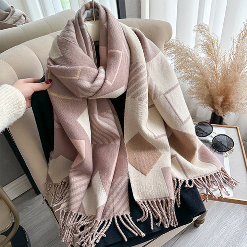 Chic Reversible Winter Poncho Shawl gathered in hand showing blush pink and beige geometric print with fringe tassel detail
