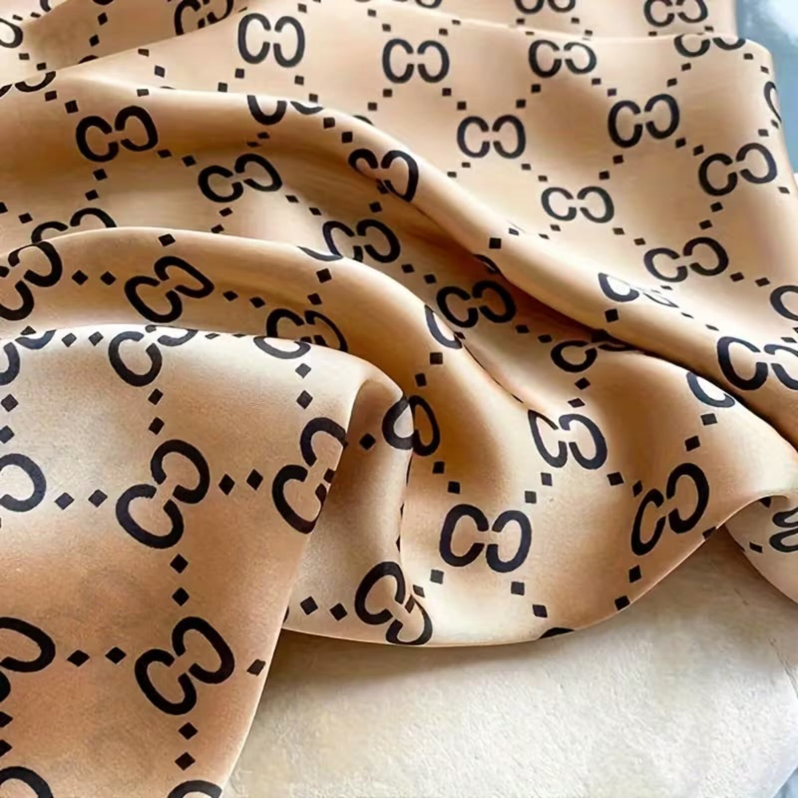 Beige fabric with black logo pattern on a light background