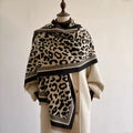 Classic Safari Leopard Knit Wrap in beige and black leopard print, elegantly draped over a cream coat.