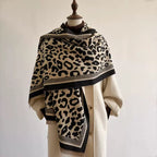 Classic Safari Leopard Knit Wrap in beige and black leopard print, elegantly draped over a cream coat.