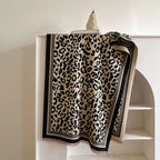 Classic Safari Leopard Knit Wrap featuring an all-over leopard print with contrasting black border and soft knit texture.