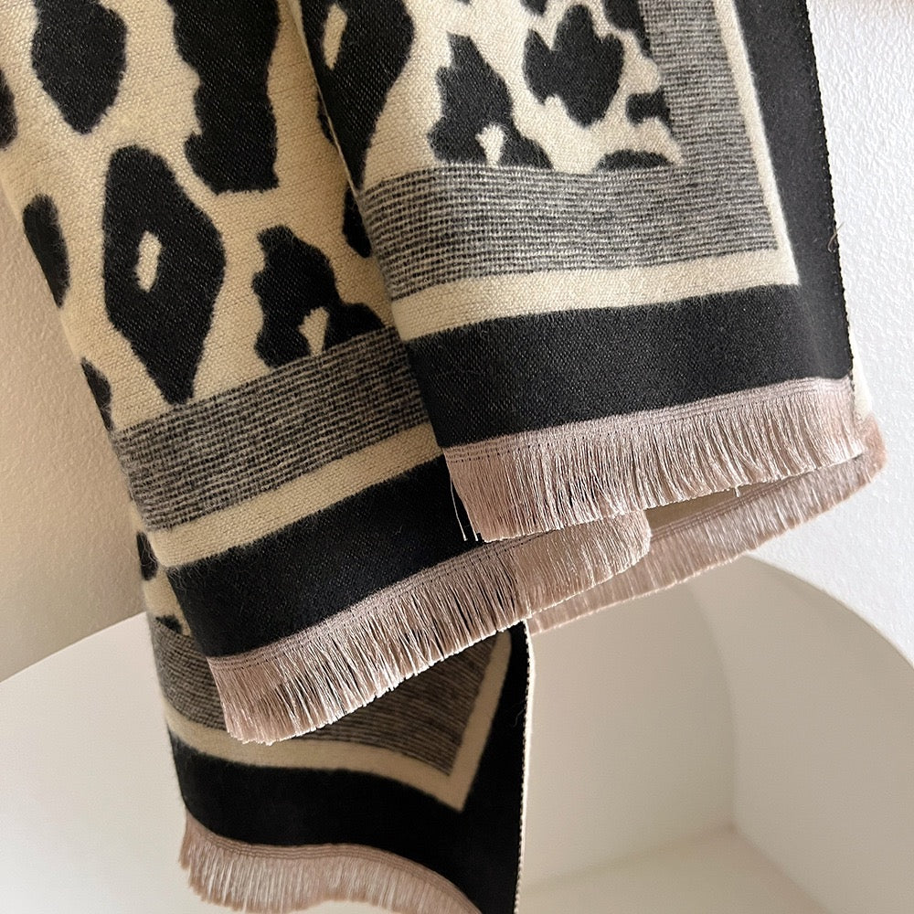 Close-up of the Classic Safari Leopard Knit Wrap showcasing soft knit fabric, leopard print, and delicate fringe detailing.