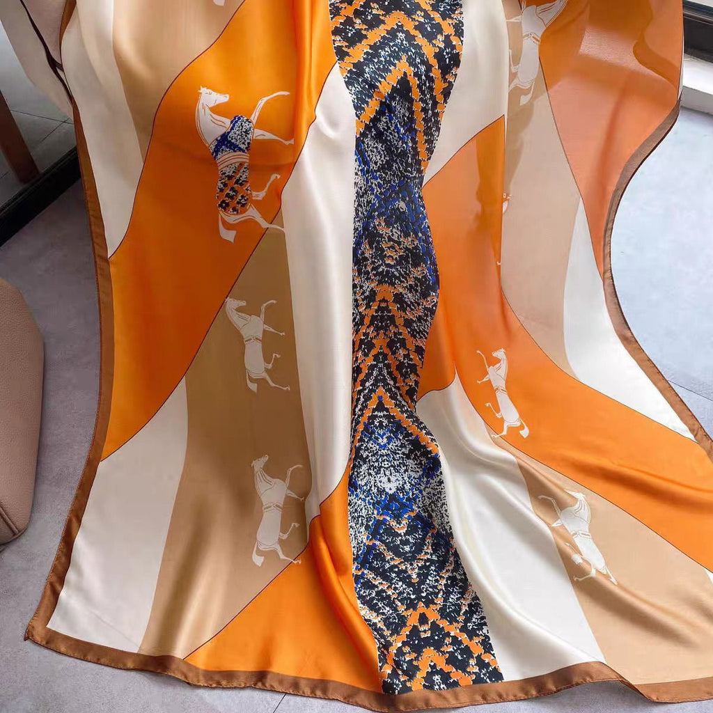 Close-up of equestrian horse print and chain border detail - orange beige navy silk scarf pattern