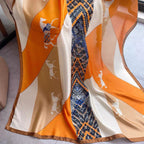 Close-up of equestrian horse print and chain border detail - orange beige navy silk scarf pattern
