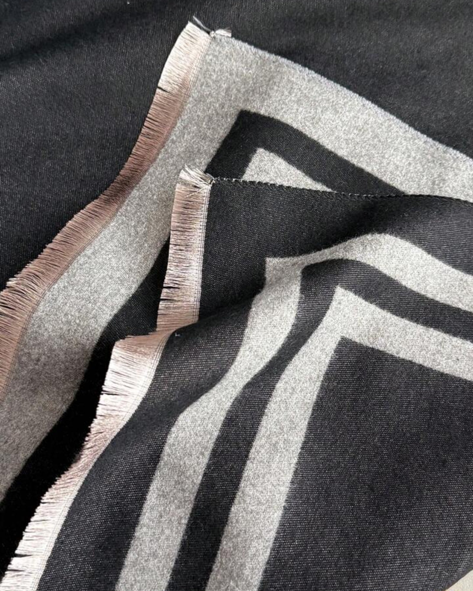 Close-up of Cozyzone Classic Striped Knit Scarf Shawl showing jacquard woven stripe texture detail in black and grey faux cashmere fabric
