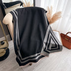Cozyzone Classic Striped Knit Scarf Shawl worn as a shoulder wrap showing black and grey stripe jacquard faux cashmere drape
