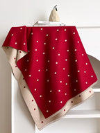 The Crimson Hearts Cashmere Wrap laid flat displaying full crimson heart motif print pattern on soft deep red faux cashmere base
