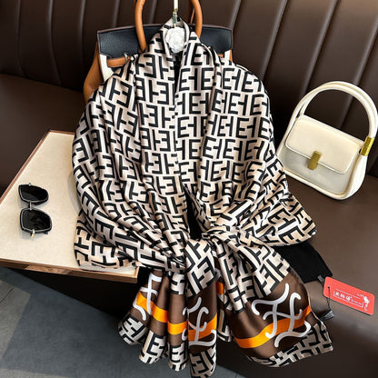 Designer logo print imitation silk scarf in black white brown orange - geometric luxury scarf flat lay with accessories
