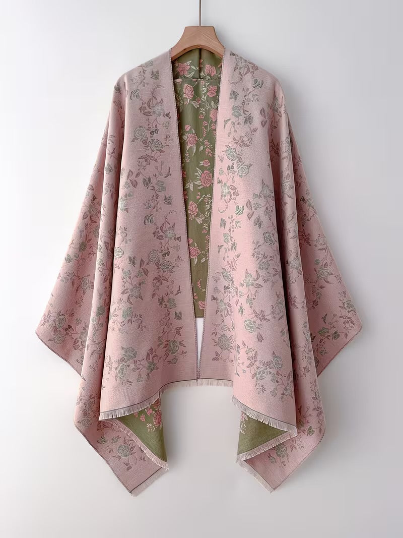 Enchanted Rose Two-Tone Fringed Wrap on hanger showing dusty rose side as a full open cape with green rose floral print detail and fringe edge
