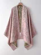 Enchanted Rose Two-Tone Fringed Wrap on hanger showing dusty rose side as a full open cape with green rose floral print detail and fringe edge
