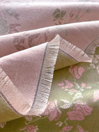 Close-up of Enchanted Rose Two-Tone Fringed Wrap showing cream fringe edge and faux cashmere fabric texture with sage green and dusty rose tones

