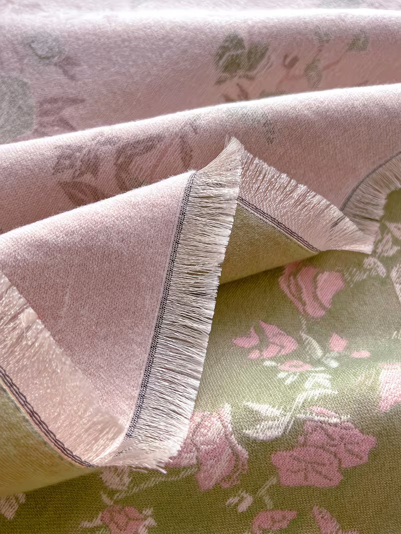 Close-up of Enchanted Rose Two-Tone Fringed Wrap showing cream fringe edge and faux cashmere fabric texture with sage green and dusty rose tones
