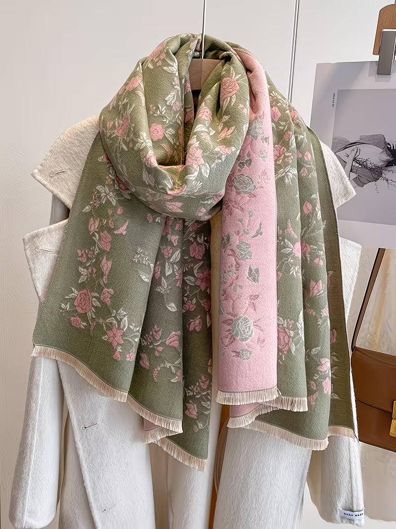 Enchanted Rose Two-Tone Fringed Wrap looped on hanger showing sage green side with pink rose floral print and cream fringe edge
