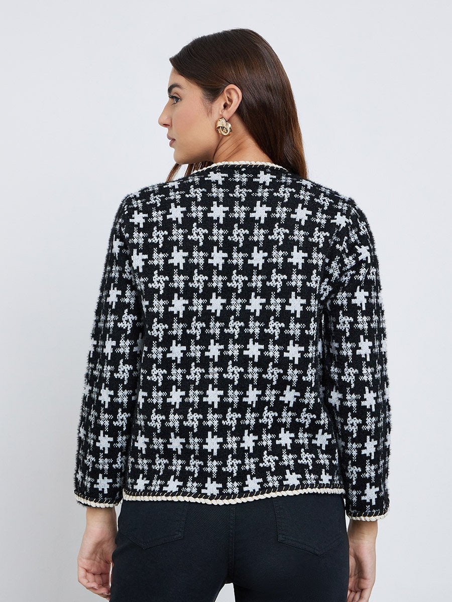 Back view of a black and white geometric knit cardigan for women with full sleeves and contrast braided hem trim.