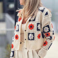 Woman wearing Garden Squares Crochet Cardigan in beige with navy and orange floral granny-square pattern